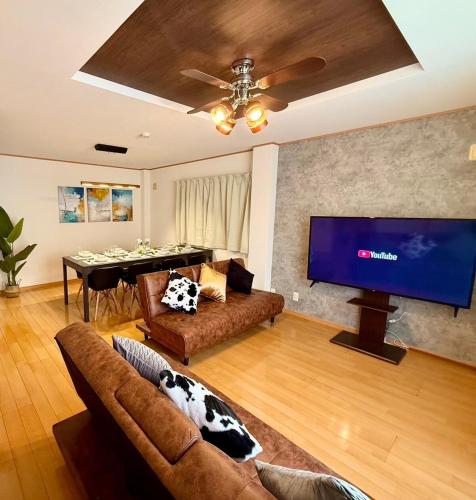 a living room with a couch and a large flat screen tv at Spacious Family Home Sleeps 13 Near USJ & Osaka Station in Osaka