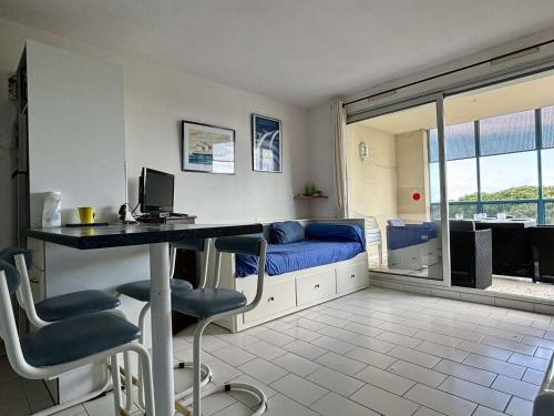 Cette chambre comprend un bureau avec un ordinateur et un lit. dans l'établissement Appartement 2 pièces 4 couchages ARGELES SUR MER AR250-302, à Argelès-sur-Mer