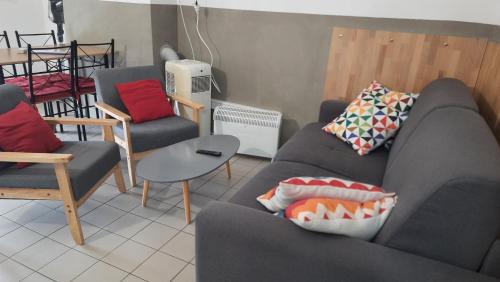 a living room with a couch and two chairs at La Mansarde in Saint-Émilion