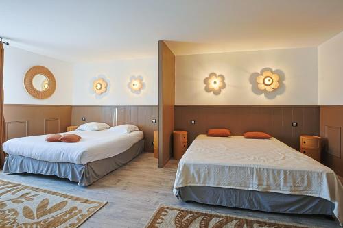 two beds in a hotel room with two beds sidx sidx sidx at Manoir'Hastings in Bénouville