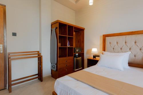 a bedroom with a bed and a dresser and a bed sidx sidx sidx sidx at Ivory Resort Dikwella in Dickwella