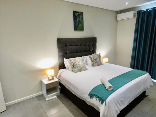 a bedroom with a large bed with two pillows at The Executive - Exclusive Self-Catering Apartments - Ezulwini in Ezulwini