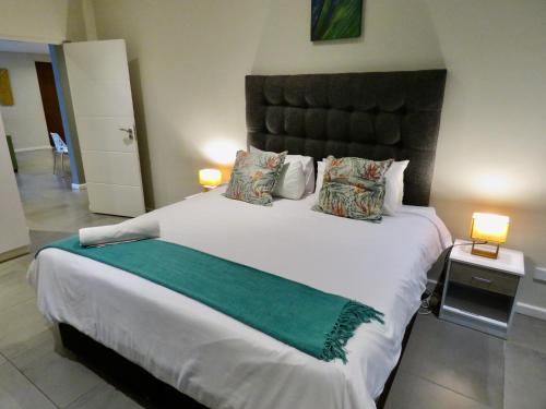 a bedroom with a large white bed with two lamps at The Executive - Exclusive Self-Catering Apartments - Ezulwini in Ezulwini