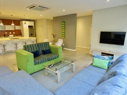 a living room with two couches and a tv at The Executive - Exclusive Self-Catering Apartments - Ezulwini in Ezulwini