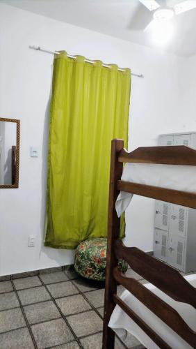 a room with a green curtain and a bed at Casa Monjardim in Vitória