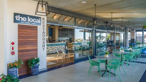a restaurant with tables and chairs and a sign at Ballito Hills Modern Coastal Living in Ballito