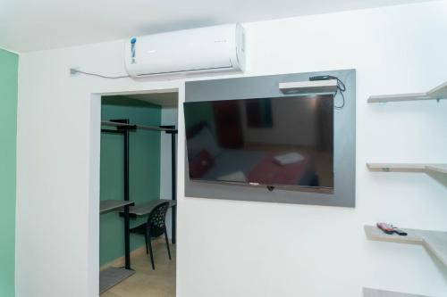 a room with a television on a wall at Hotel Galería La Vieja Sara in Ríohacha