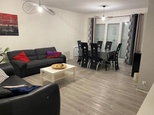 a living room with a couch and a table at Les Fauvettes in Ouzouer-sur-Loire