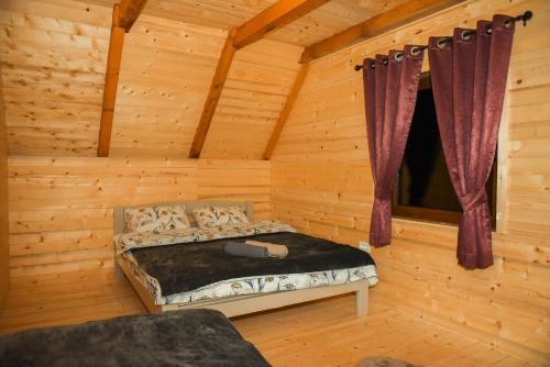a bedroom with a bed in a log cabin at Vila Kraljica Planina in Šavnik