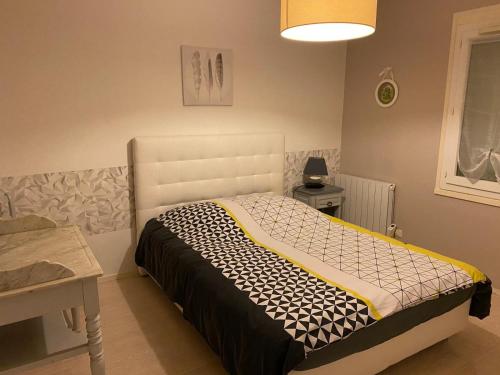 a bedroom with a bed with a white headboard at Les Fauvettes in Ouzouer-sur-Loire