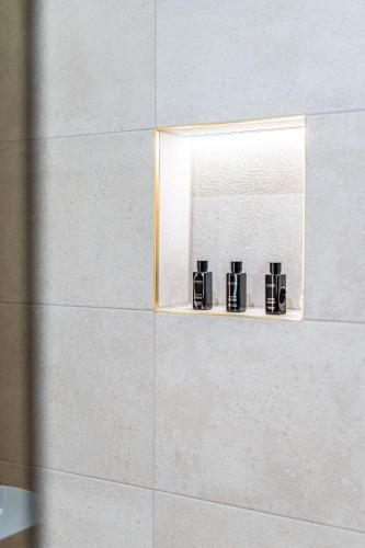 three coffee cups sitting on a shelf in a bathroom at St Marys Quarters in Nottingham