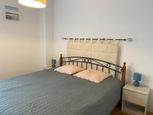 une chambre avec un grand lit avec deux oreillers dans l'établissement Appartement 2 chambres avec terrasse au cœur de Perros-Guirec, parking inclus - FR-1-368-449, à Perros-Guirec