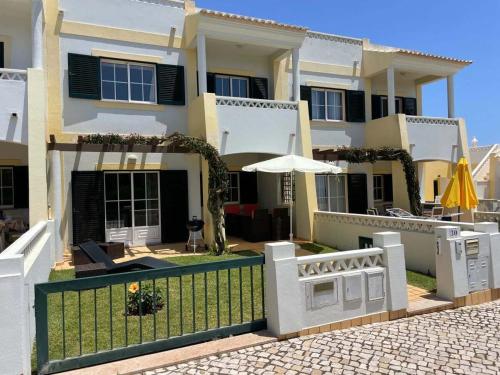 a house with a fence and an umbrella at 30 Terracos de Benagil - Casa Domingos in Benagil