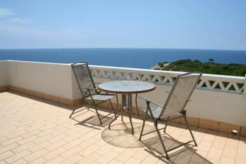a table and chairs on a balcony with the ocean at 30 Terracos de Benagil - Casa Domingos in Benagil