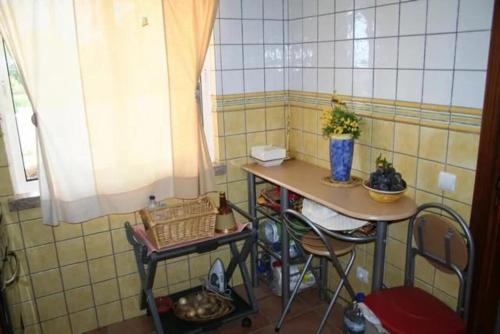 a small kitchen with a small table and chairs at 30 Terracos de Benagil - Casa Domingos in Benagil