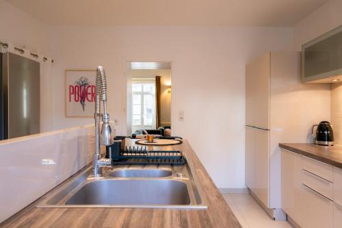 une cuisine avec un évier et un plan de travail dans l'établissement Appartement d exception port de Vannes 8 pers avec parking, à Vannes