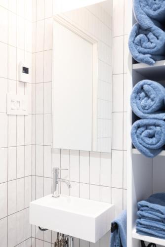 a bathroom with a sink and a mirror and towels at Chalet BLOK in Lac-Beauport