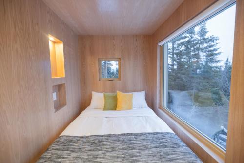 a small bedroom with a bed and a window at Chalet BLOK in Lac-Beauport