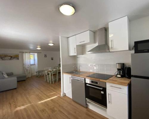 une cuisine avec des armoires blanches et un four à plaques de cuisson dans l'établissement Foyer Magistérien, à Porta