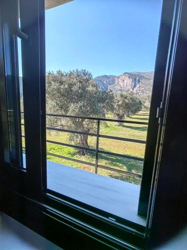 a window looking out at a view of a field at Villa Maximos in Episkopí