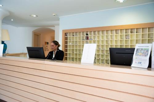 a woman sitting at a counter with a laptop at Cala Della Torre Resort in La Caletta