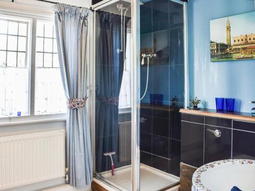 a bathroom with a shower and a sink at Historic Tudor Cottage, free parking, sleeps 6 and dog friendly! in Wingham