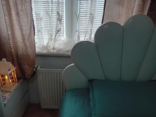 a green chair in a room with a window at Ruska's Guesthouse in Kveda-Bashi