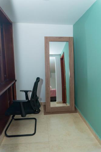 a black chair in a room with a mirror at Hotel Galería La Vieja Sara in Ríohacha
