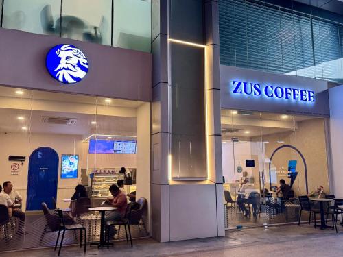 a zus coffee store with people sitting at tables at NEW Bangsar Trade Centre KL Mid Valley LRT Bangsar in Kuala Lumpur