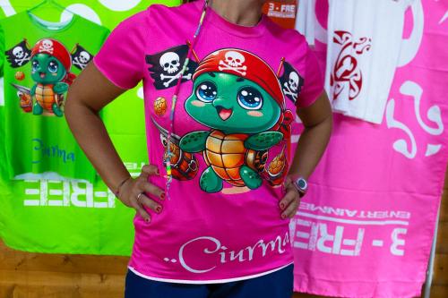 a woman wearing a pink shirt with a cimimus on it at Cala Della Torre Resort in La Caletta