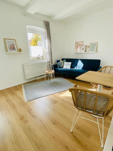 a living room with a blue couch and a table at Kleines Haus bei Hannover in Sehnde
