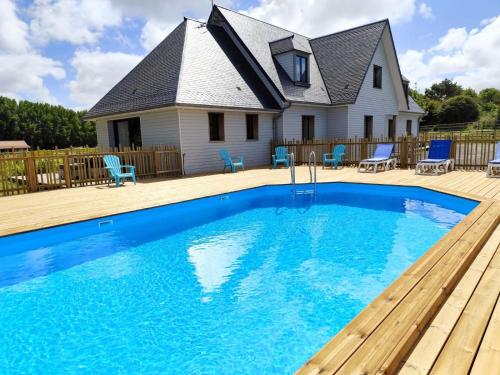 a house with a blue swimming pool on a wooden deck at Camping la Haie Penée **** in Saint-Quentin-en-Tourmont