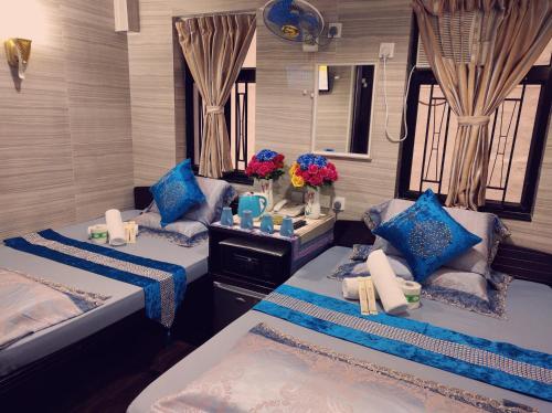 two beds in a room with blue pillows at Day and Night Hostel Block D 10th floor in Hong Kong