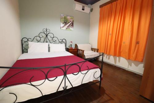 a bedroom with a bed with a red and white blanket at Ioannis House Apartment in Asprovalta
