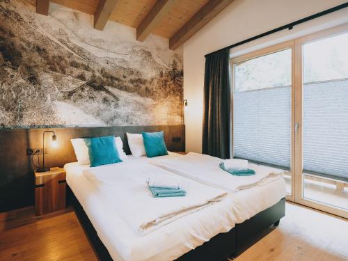 ein Schlafzimmer mit einem großen Bett mit blauen Kissen in der Unterkunft Studio Niederseer by we rent, JOKERCARD INCLUDED in Saalbach-Hinterglemm