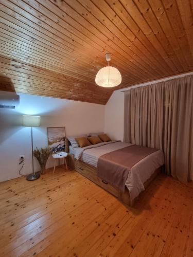 a bedroom with a large bed with a wooden ceiling at Best View Kolasin in Kolašin