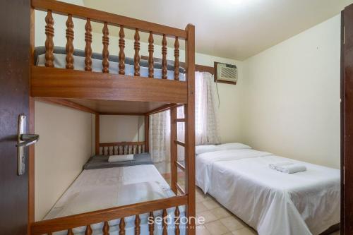 a bedroom with two bunk beds and a ladder at Casa a 4 min a pé da praia em Porto Belo BRR0097 in Perequê