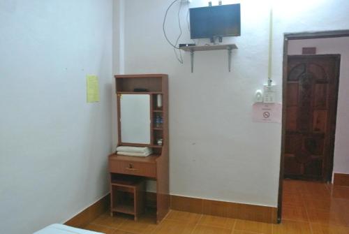 een kamer met een spiegel en een tv aan de muur bij Phonephithak Guesthouse in Pakbeng