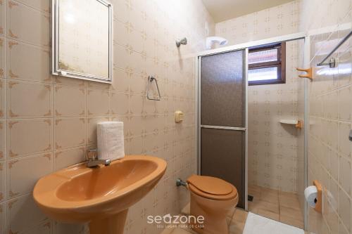 a bathroom with a toilet and a sink and a shower at Casa a 4 min a pé da praia em Porto Belo BRR0097 in Perequê