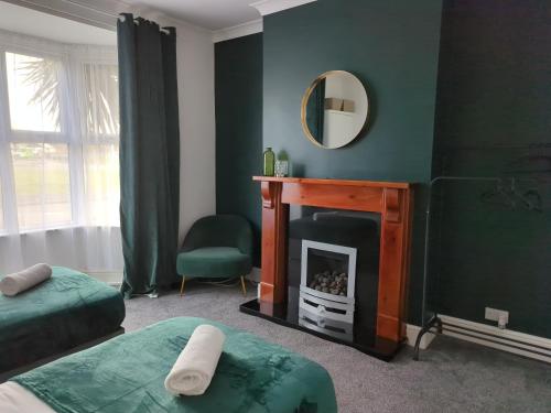 a living room with a fireplace and a mirror at Charming 3-Bedroom House - Prime Location in Wolverhampton! in Wolverhampton