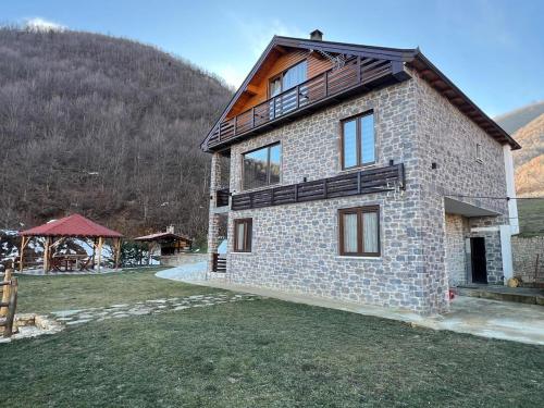 a large brick house with a mountain in the background at Saselisht Harmony 4 Bedroom Villa in Pogradec