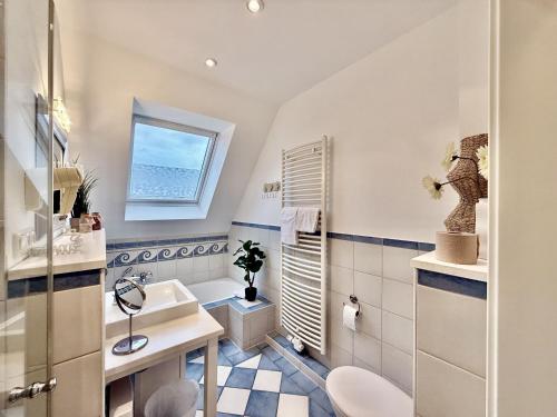 ein Badezimmer mit Waschbecken und Toilette und einem Fenster in der Unterkunft FeWo Harleglück - Carolinensiel in Wittmund