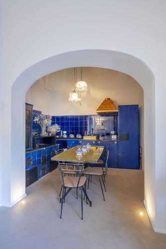 a kitchen with blue cabinets and a table and chairs at Fiermonte Museum by La Fiermontina in Lecce