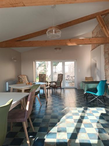 a room with tables and chairs and a ceiling with beams at Le Jardin Des Cèdres in Lavaur