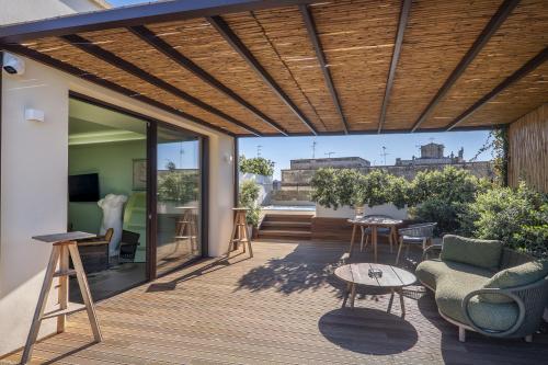 a patio with a wooden roof with a table and chairs at Fiermonte Museum by La Fiermontina in Lecce