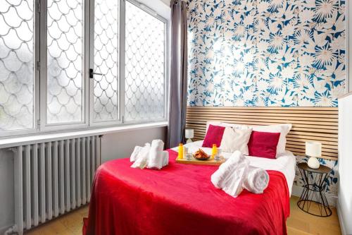 - une chambre avec un lit rouge et un plateau de nourriture dans l'établissement Bluestay 48 - Superb apartment in Paris, à Paris