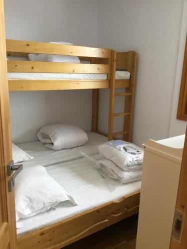 - un lit superposé en bois avec 2 oreillers dans l'établissement Appartement 5 Personnes La Plagne 1800, à La Plagne Tarentaise