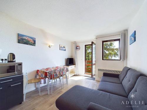 un salon avec un canapé et une table dans l'établissement Studio refait à neuf avec balcon, garage et accès direct aux pistes, proche commerces et services - FR-1-398-623, à Montvalezan
