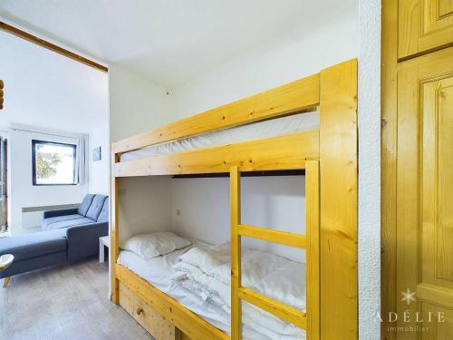 Ce lit superposé se trouve dans un dortoir doté d'un canapé. dans l'établissement Studio refait à neuf avec balcon, garage et accès direct aux pistes, proche commerces et services - FR-1-398-623, à Montvalezan