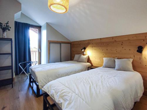 a bedroom with two beds and a large window at Superbe Chalet Duplex 3* avec Parking et WIFI au Pied des Pistes, Valmorel - FR-1-356-392 in Valmorel